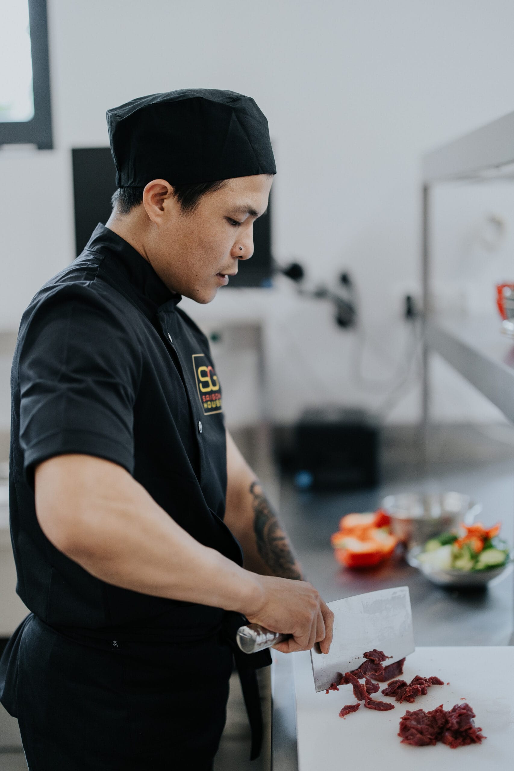 Kucharz kroi mięso przygotowując posiłek w restauracji Saigon House.